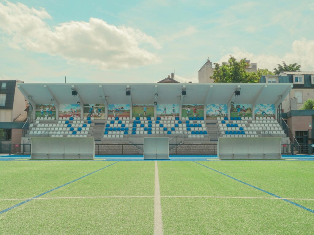pexels-photo-17952360-17952360 A vibrant tennis stadium in Vanves, France, with colorful seating and murals.