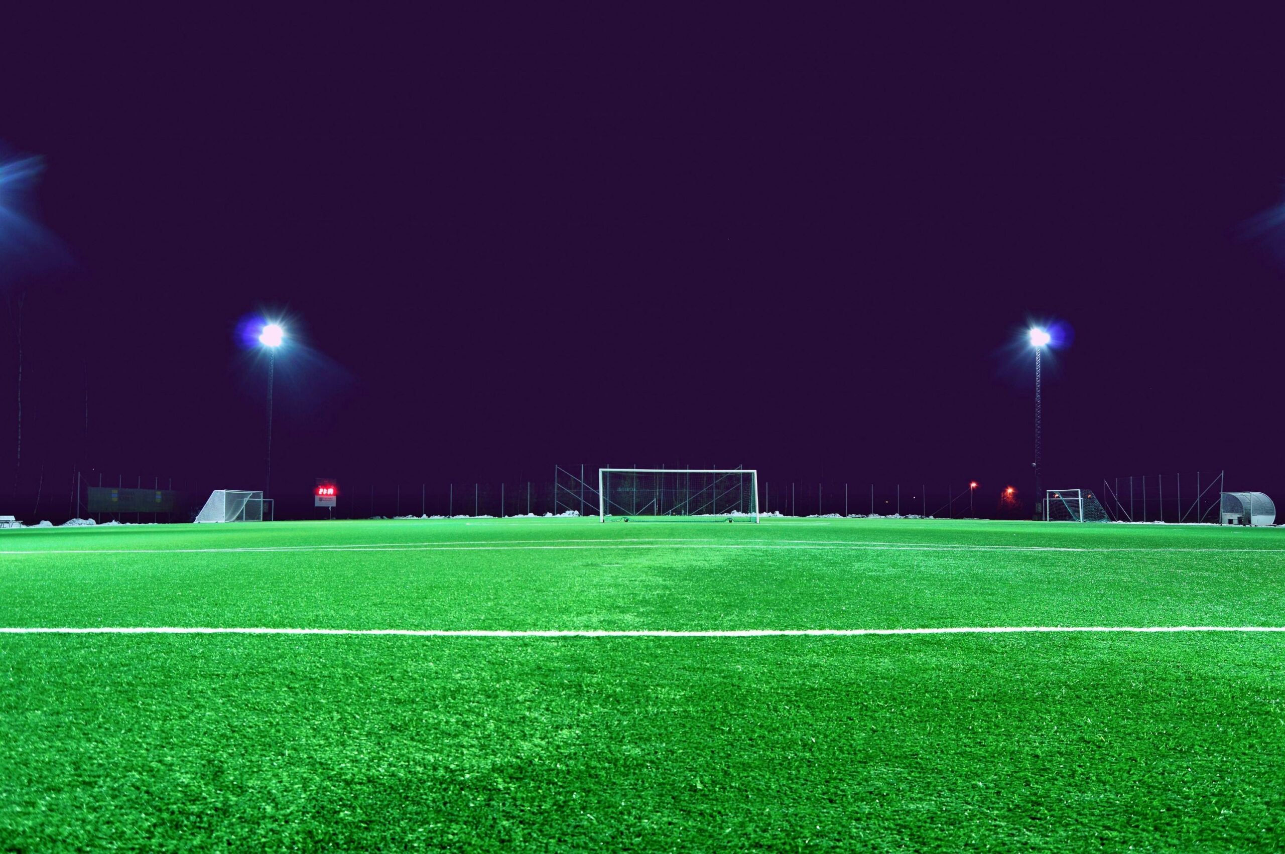 pexels-photo-399187-399187 A brightly lit soccer field at night in Norrtälje, Sweden, showcasing green turf and stadium lights.